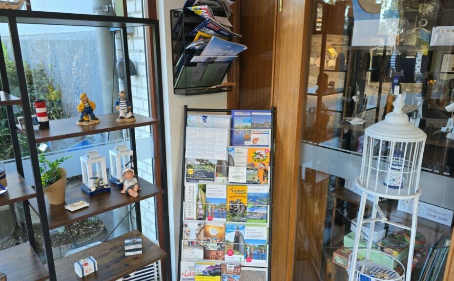 Vitrine mit Souvenirs, Postkarten und Informationsmaterial in einem Geschäft. Bietet eine Vielzahl von Andenken und touristischen Informationen.